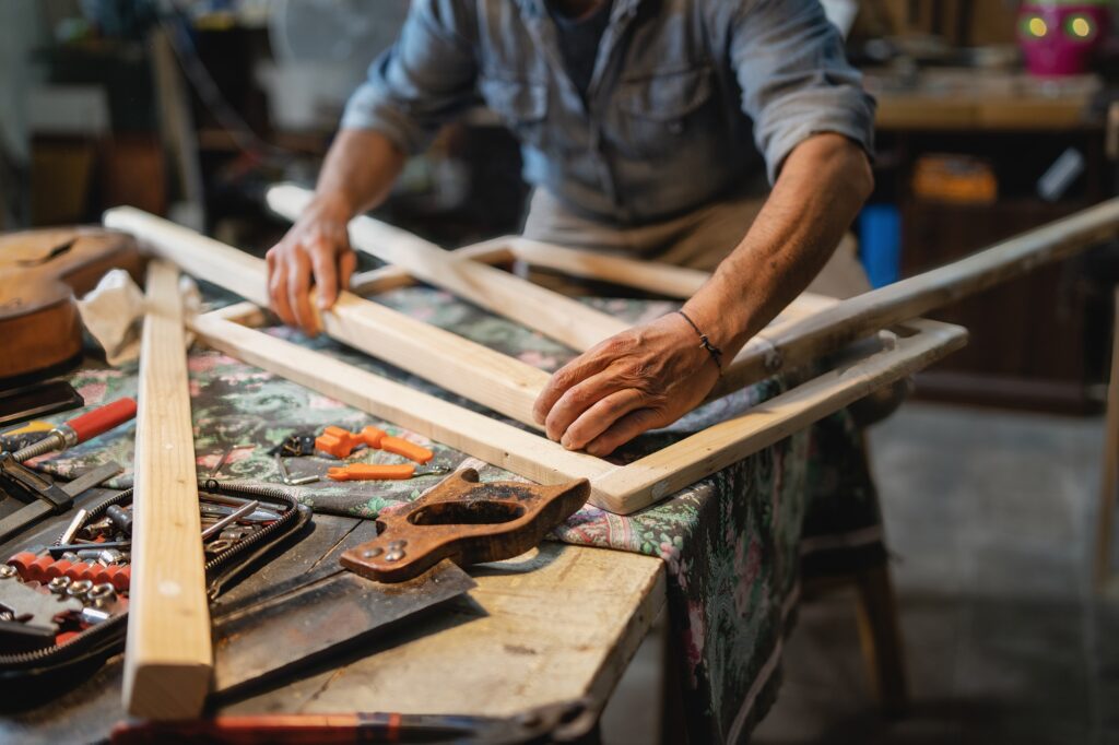 A carpenter builds a wooden frame on the workbench in the carpentry shop